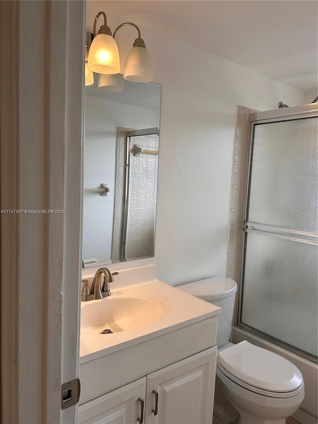 full bathroom with toilet, shower / bath combination with glass door, and vanity