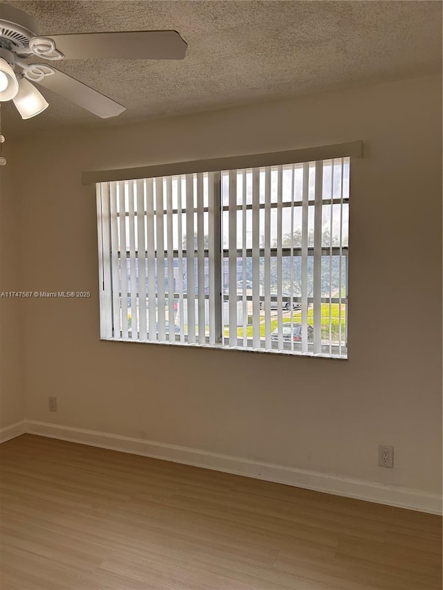 unfurnished room with a textured ceiling, hardwood / wood-style floors, and ceiling fan