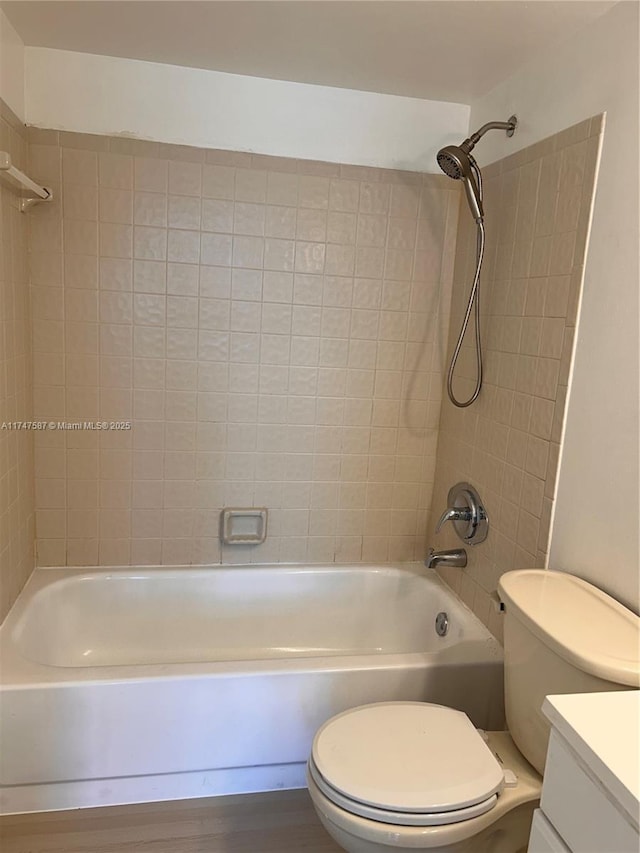 full bathroom featuring toilet, wood-type flooring, vanity, and tiled shower / bath