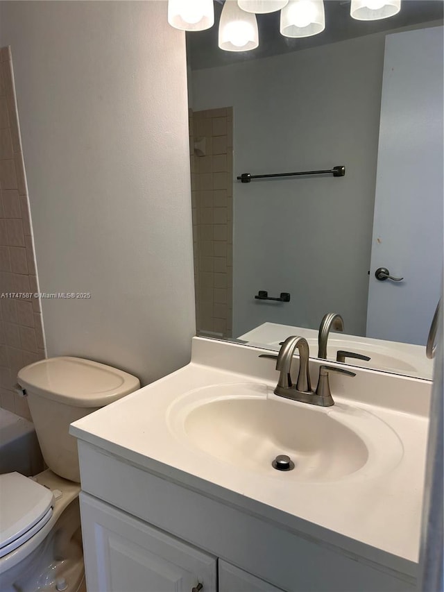 full bathroom with tiled shower / bath combo, vanity, and toilet