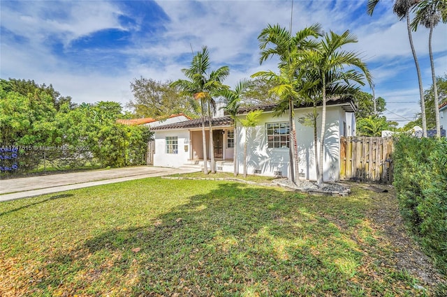 view of front of house featuring a front yard, fence, and stucco siding