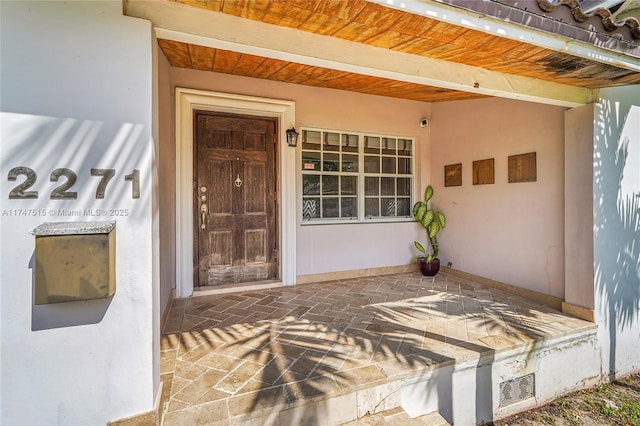 doorway to property featuring visible vents and stucco siding