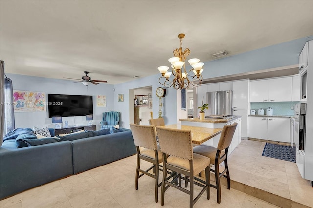 dining area with light tile patterned flooring, visible vents, and ceiling fan with notable chandelier