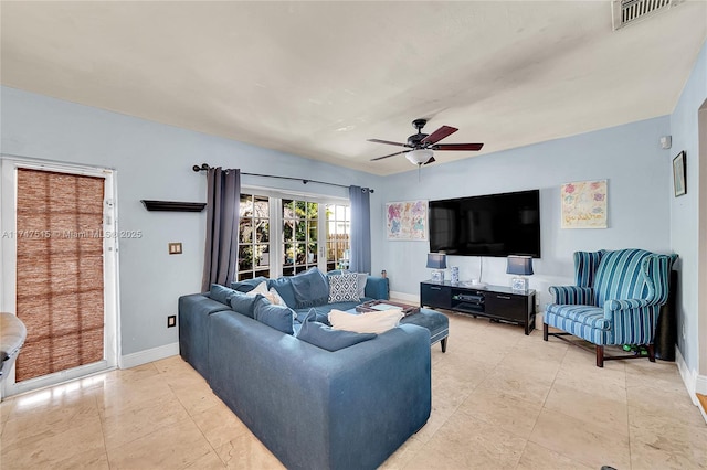 living area with ceiling fan, light tile patterned flooring, visible vents, and baseboards