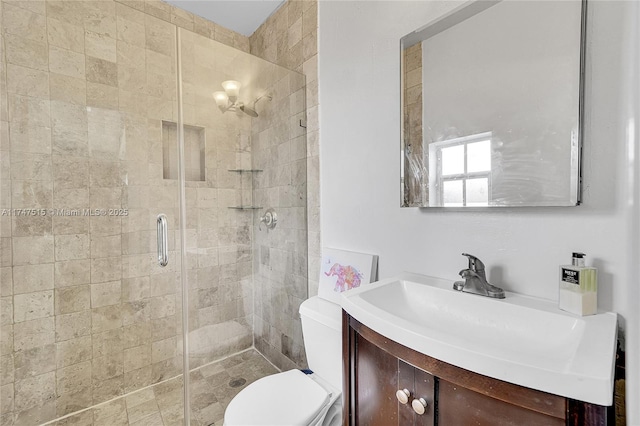 bathroom with toilet, a stall shower, and vanity