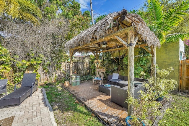 view of patio / terrace with a deck, fence, an outdoor living space, and a gazebo