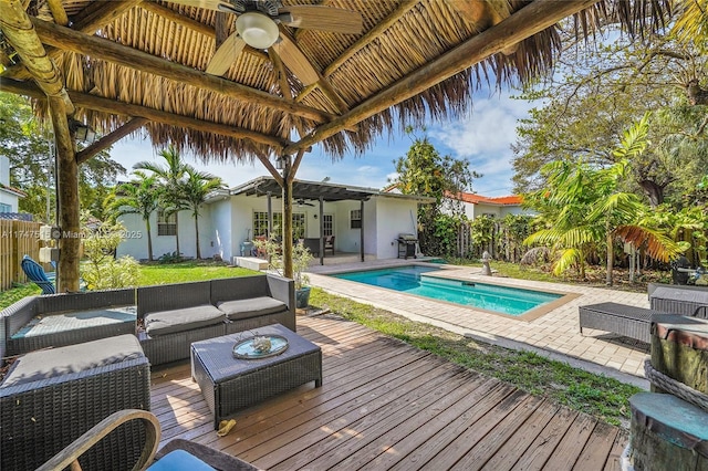 deck featuring an outdoor hangout area, fence, a ceiling fan, grilling area, and an outdoor pool