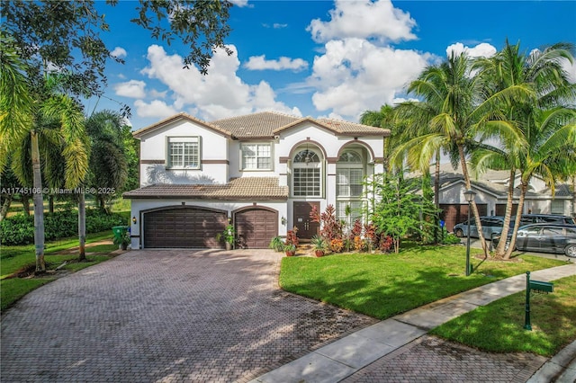 mediterranean / spanish home with a front lawn and a garage