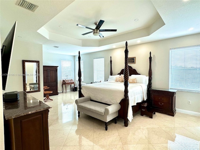 bedroom with a tray ceiling and ceiling fan