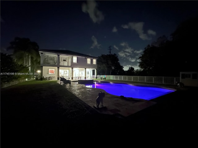 pool at twilight with a patio area