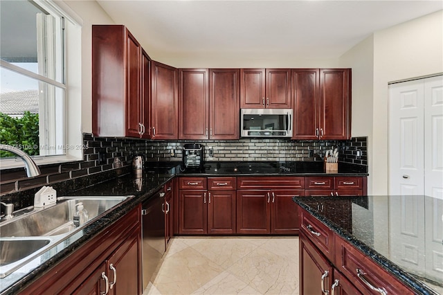 kitchen featuring sink, dark stone countertops, black appliances, and tasteful backsplash