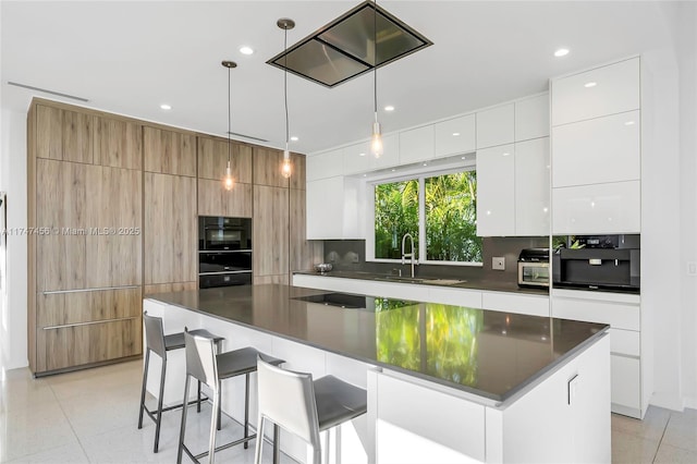 7331 Belle Meade Island Dr, Miami, FL 33138 - kitchen featuring modern cabinets, a sink, dark countertops, a breakfast bar, and recessed lighting