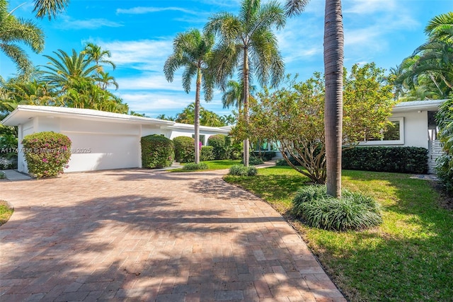 7331 Belle Meade Island Dr, Miami, FL 33138 - view of front of home featuring an attached garage, decorative driveway, stucco siding, and a front yard