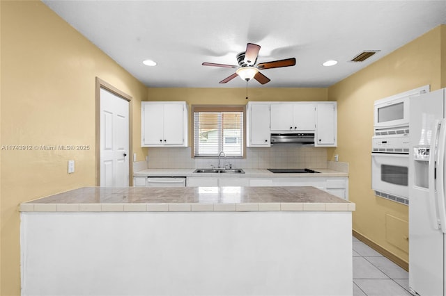 kitchen with white cabinetry, tile counters, sink, white appliances, and decorative backsplash