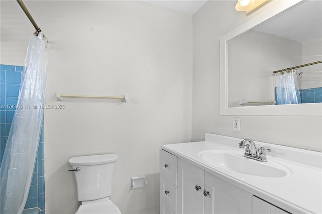 bathroom featuring toilet, vanity, and a shower with curtain