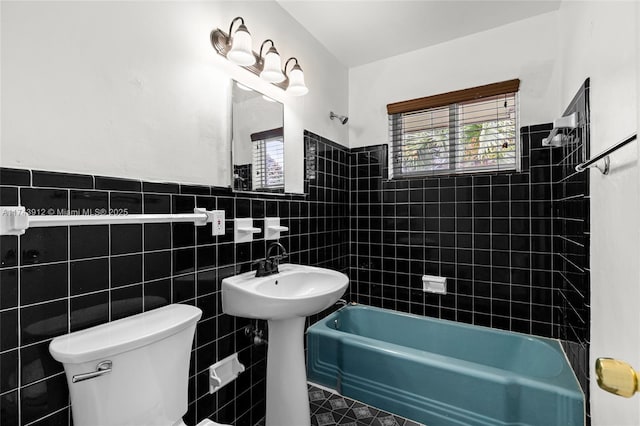 bathroom with tile walls, tiled shower / bath, and toilet