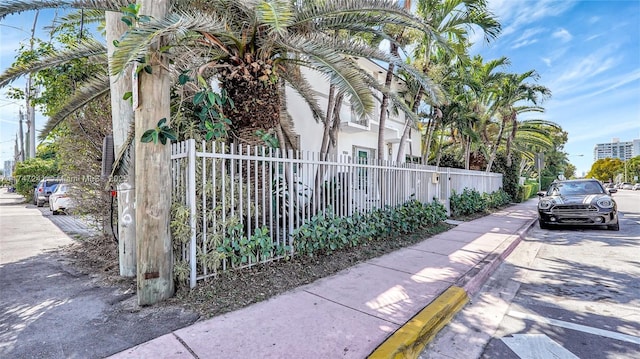 view of side of property featuring fence and stucco siding