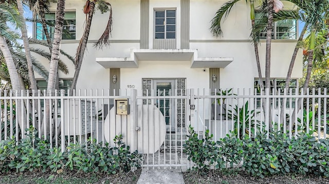 view of front facade with a fenced front yard and stucco siding