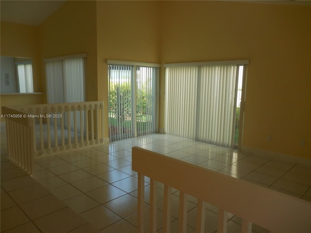 spare room featuring lofted ceiling and light tile patterned floors