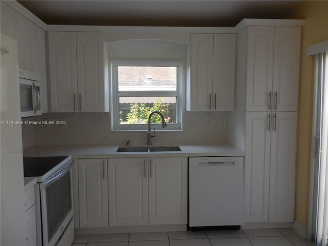 kitchen featuring sink, white appliances, white cabinetry, and light tile patterned floors