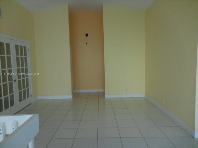 tiled spare room featuring french doors