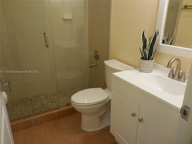 bathroom with wood-type flooring, an enclosed shower, vanity, and toilet