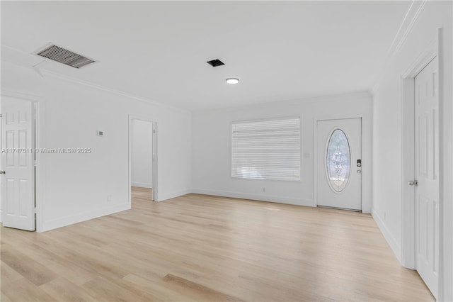 foyer entrance featuring crown molding and light hardwood / wood-style flooring