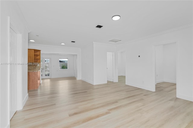 spare room featuring light wood-type flooring and crown molding