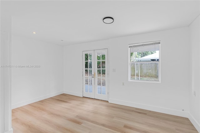 spare room with light wood-type flooring and french doors