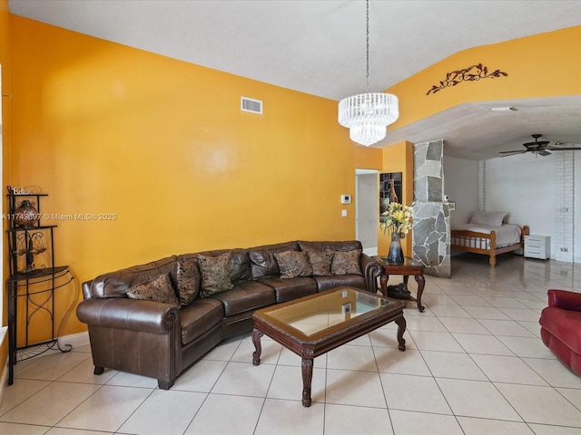 living area with light tile patterned flooring, visible vents, ceiling fan with notable chandelier, and lofted ceiling