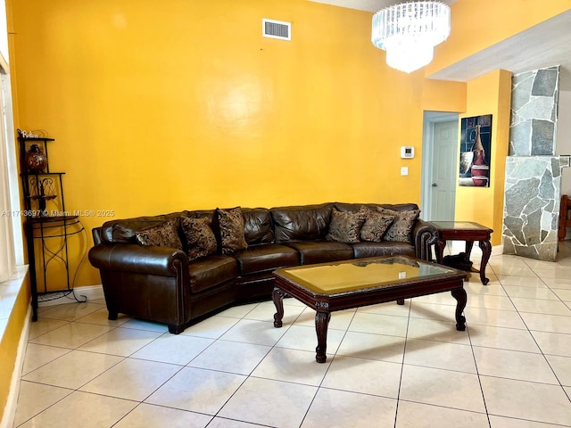 living room featuring an inviting chandelier, light tile patterned floors, baseboards, and visible vents