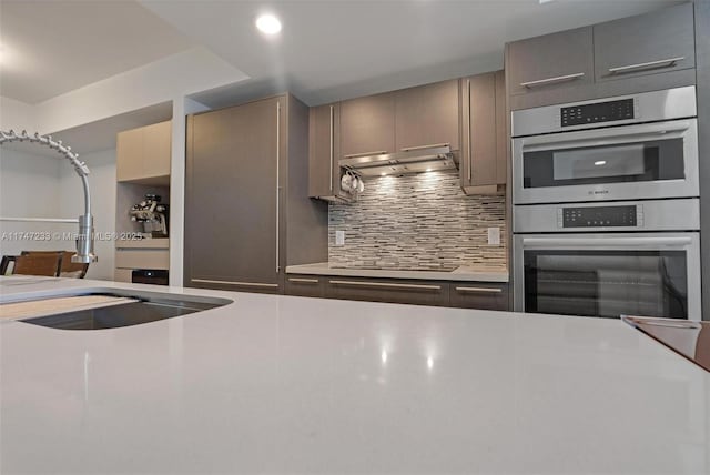 7825 NW 107th Ave Unit 618, Doral, FL 33178 - kitchen featuring black stovetop, exhaust hood, stainless steel double oven, and decorative backsplash