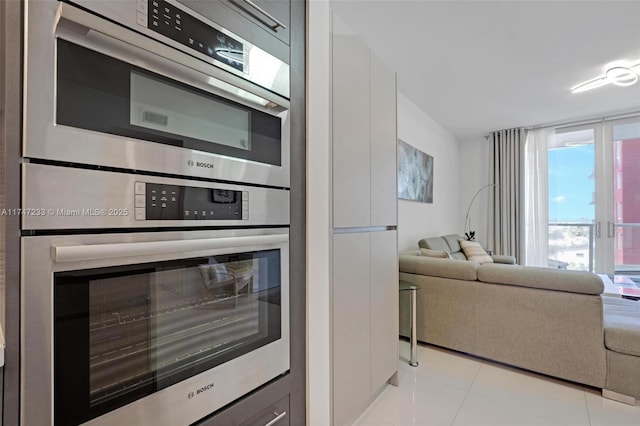 7825 NW 107th Ave Unit 618, Doral, FL 33178 - kitchen featuring white cabinetry, stainless steel double oven, and light tile patterned floors