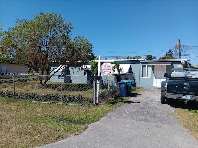 view of front of property with fence and aphalt driveway