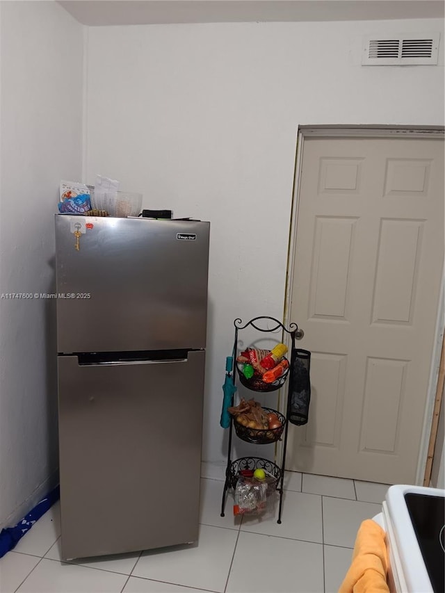 kitchen featuring stainless steel refrigerator and light tile patterned flooring