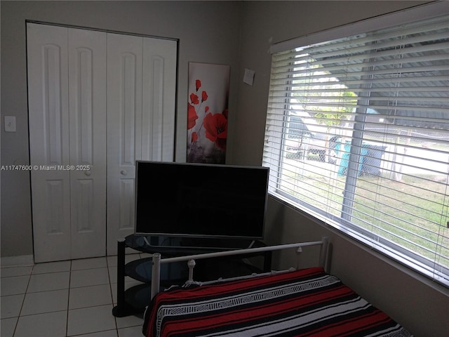 tiled bedroom with a closet