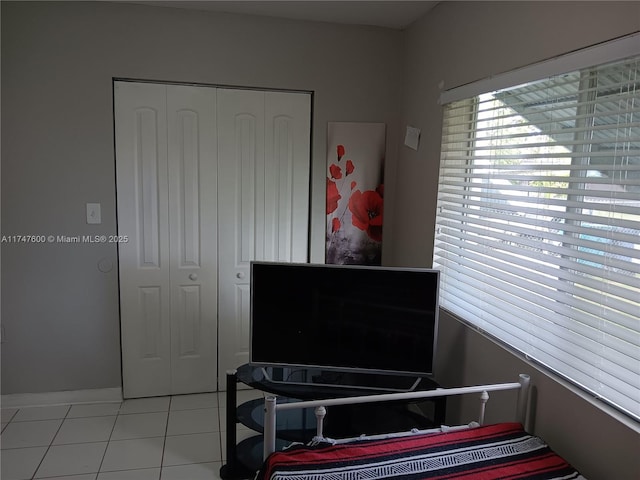 tiled bedroom with a closet