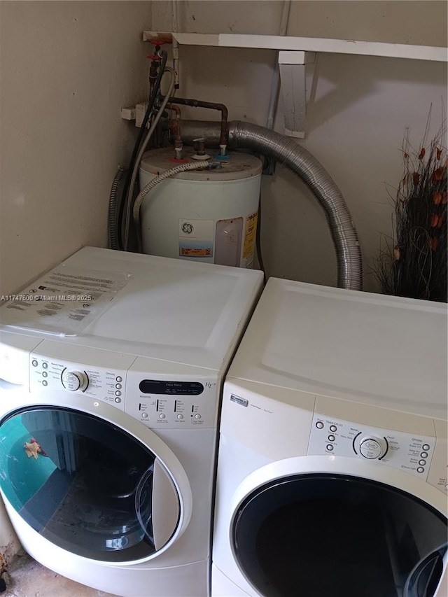 laundry area featuring electric water heater and separate washer and dryer