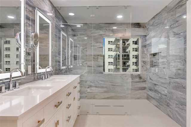 bathroom featuring a tile shower, tile walls, and vanity