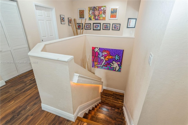 stairs with wood finished floors and baseboards