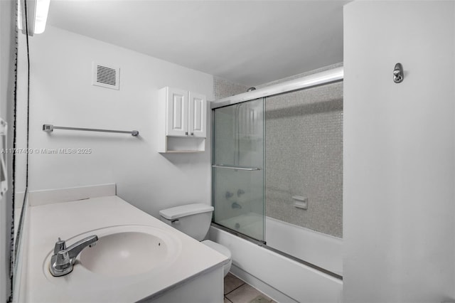 full bathroom featuring toilet, vanity, and bath / shower combo with glass door