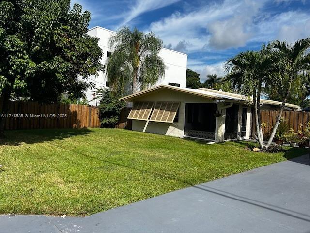 view of property exterior featuring a lawn and fence