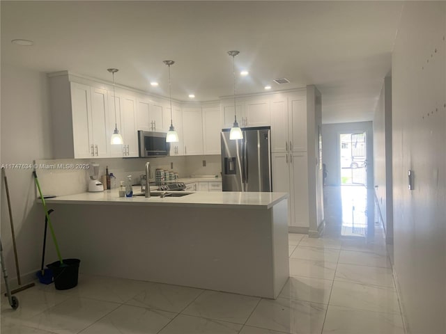 kitchen featuring stainless steel appliances, a peninsula, white cabinetry, marble finish floor, and light countertops