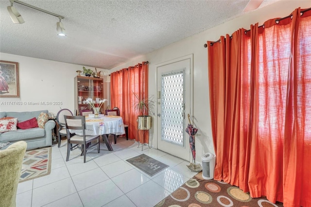 tiled dining space with a textured ceiling