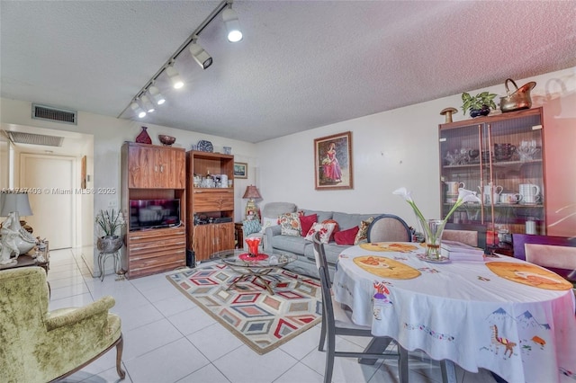 living room with a textured ceiling and light tile patterned floors