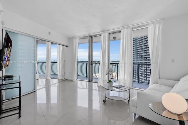 1750 N Bayshore Dr Unit 1602, Miami, FL 33132 - living area with a water view, floor to ceiling windows, tile patterned floors, and a textured ceiling