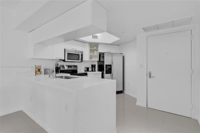 1750 N Bayshore Dr Unit 1602, Miami, FL 33132 - kitchen featuring stainless steel appliances, a peninsula, white cabinets, glass insert cabinets, and light countertops