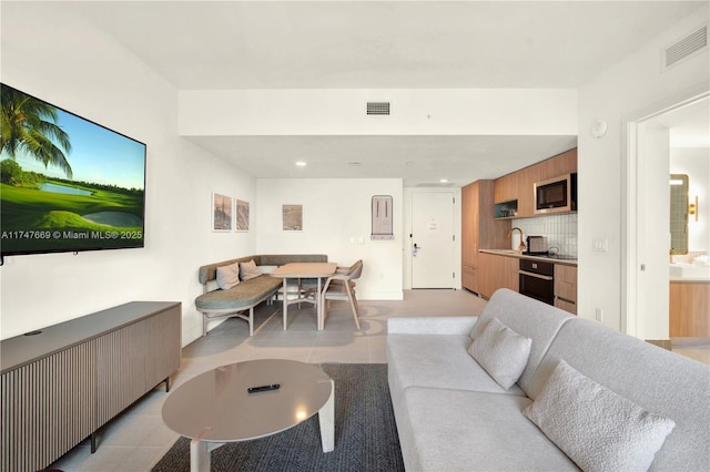 living room featuring light tile patterned floors and visible vents