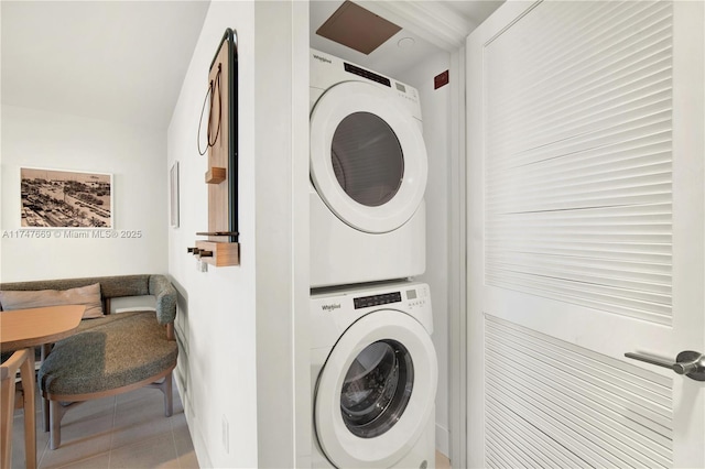 laundry area with tile patterned floors, stacked washer and clothes dryer, and laundry area