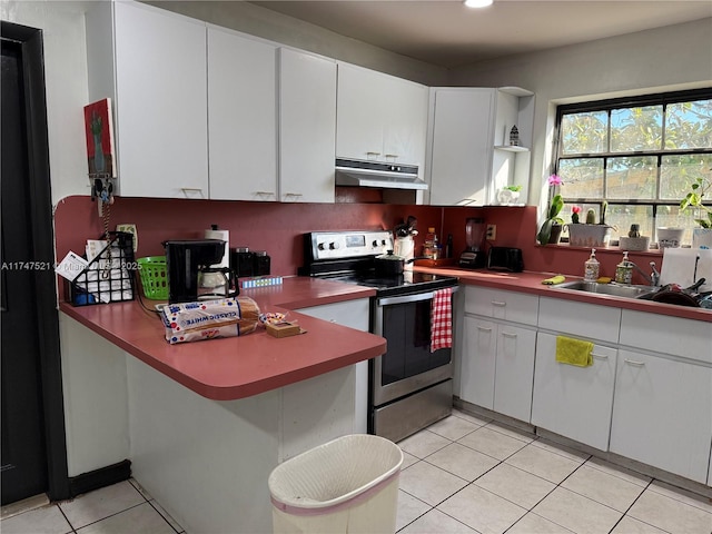 kitchen featuring stainless steel electric range, light tile patterned floors, sink, and white cabinets